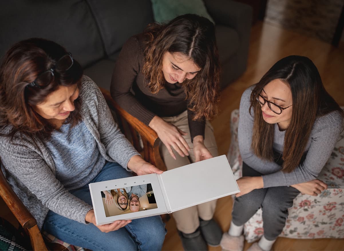 Three women on a couch watching a holiday video together in a VidDay Video Book
