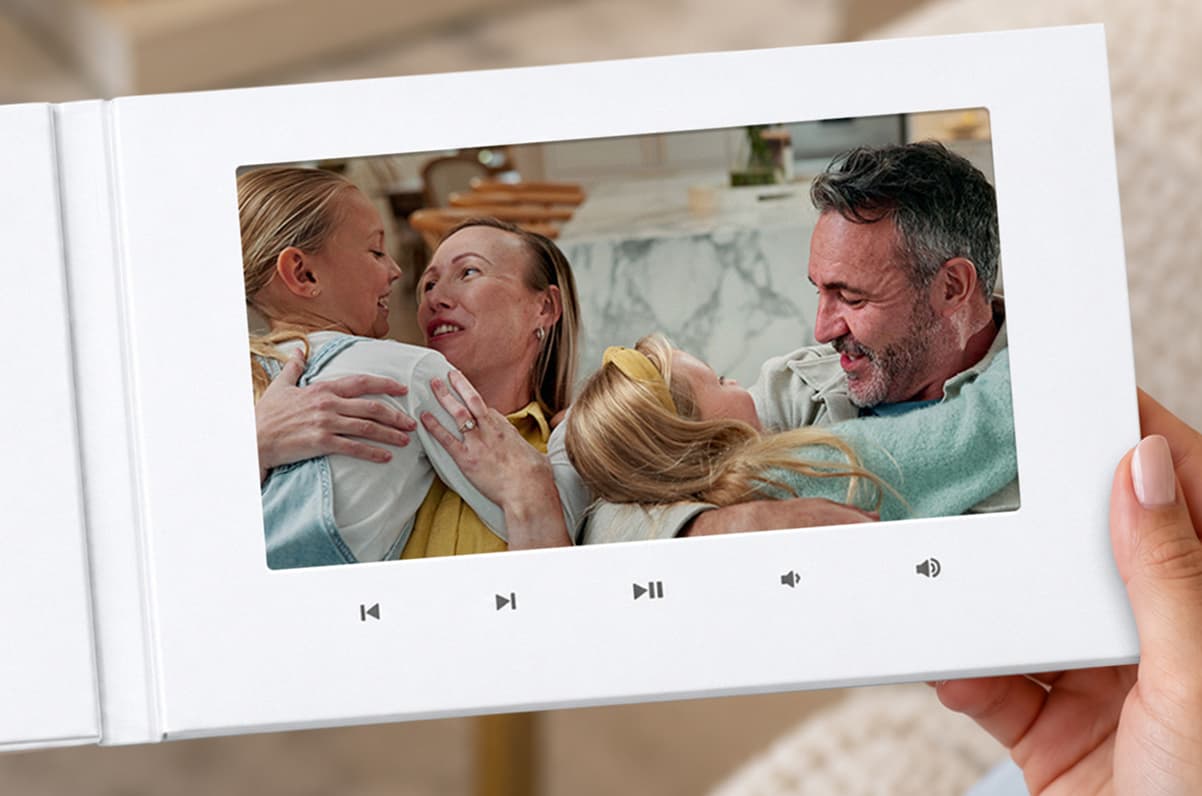 A woman opening a VidDay Video Book that plays a holiday video of a smiling couple
